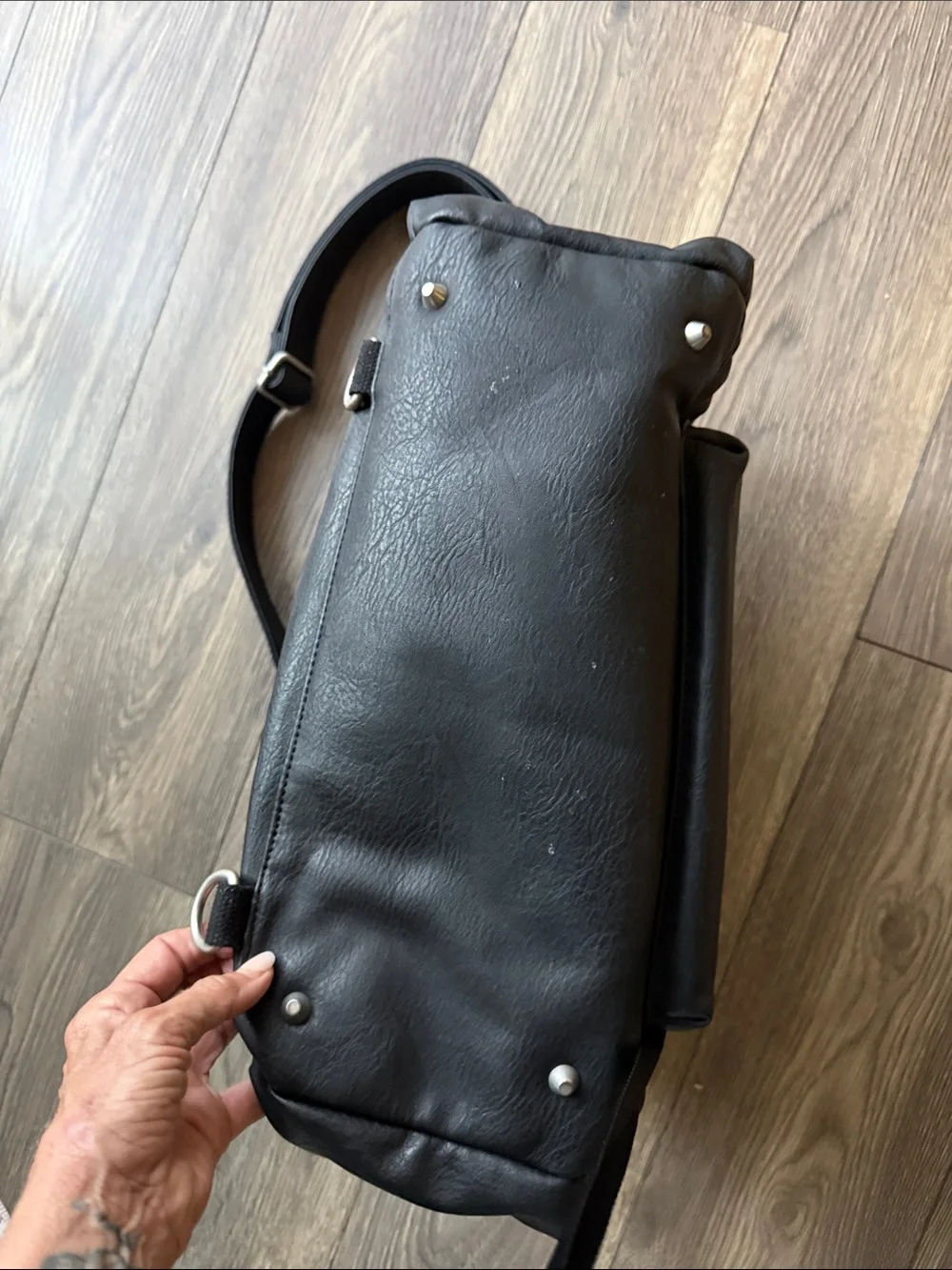 The Honest Company Black Vegan Leather Diaper Bag backpack model cross country